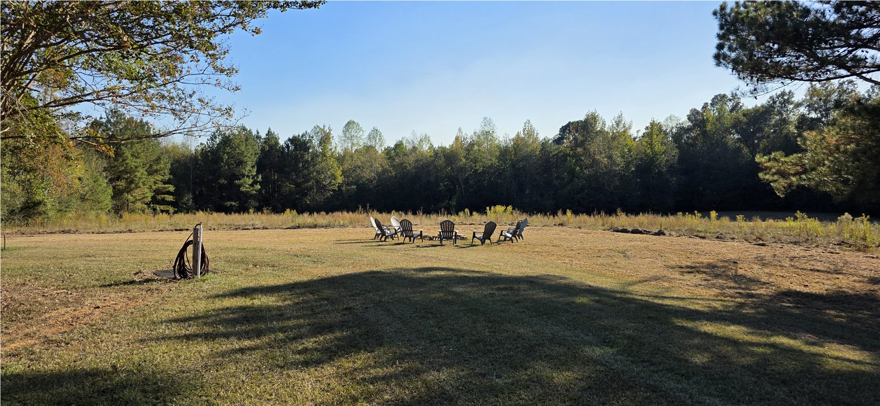 Fire ring and gathering area across the meadow